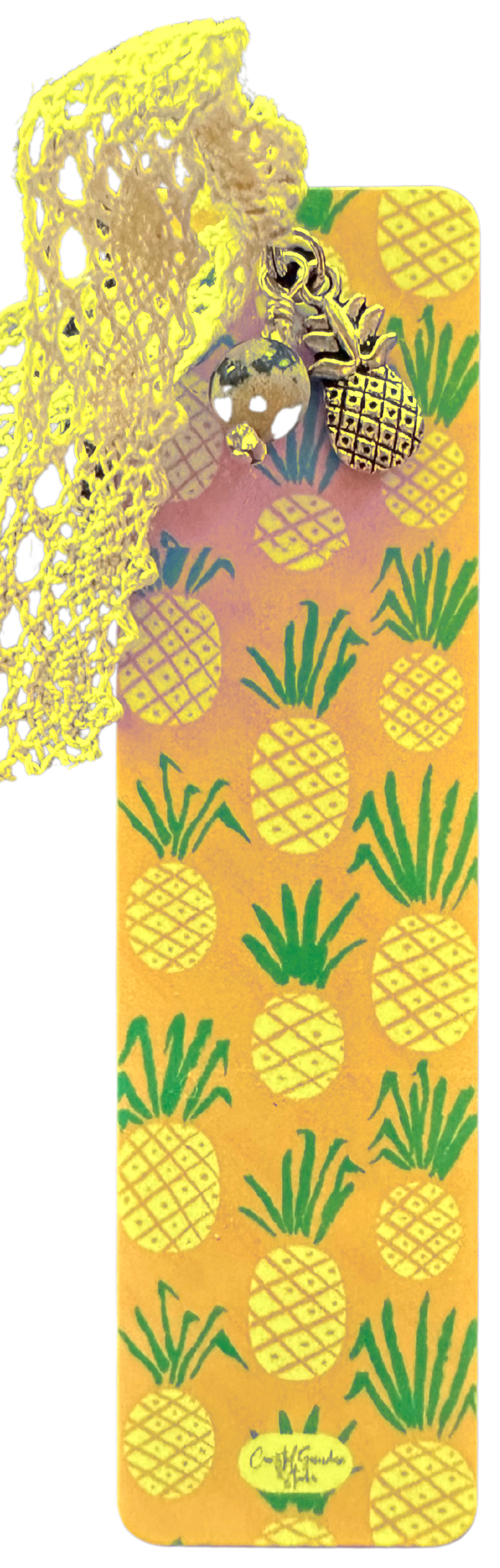 A lightweight aluminum bookmark featuring a vintage lace ribbon, a pineapple charm, and a Jasper bead, with a yellow background.