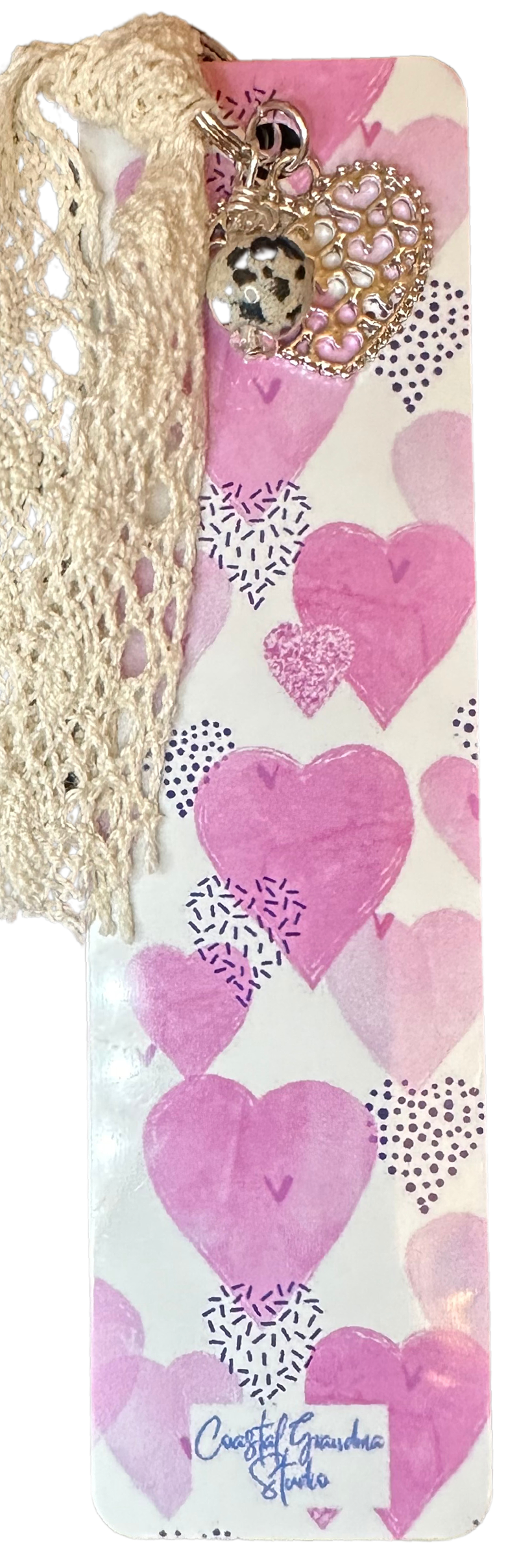 A lightweight aluminum bookmark with vintage lace,filgree heart charm, and a Jasper bead charm, featuring a pink and white coquette aesthetic  with heart shapes.